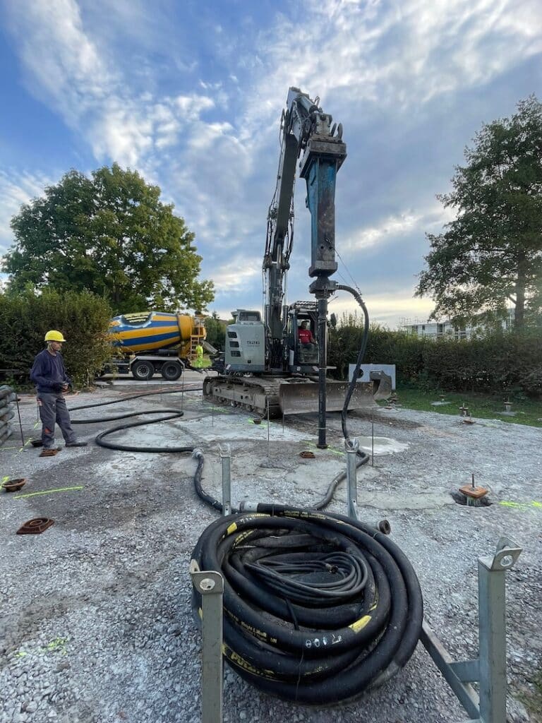 Bagger bei der Herstellung einer Pfahlgründung mit Betonmischer im Hintergrund – Brandel Bau Spezialtiefbau